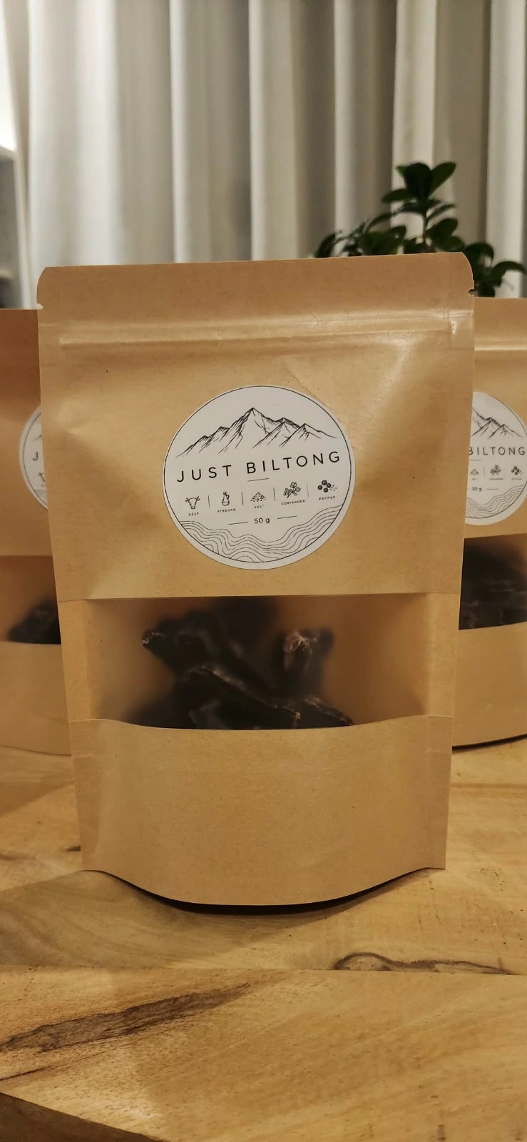 Our Just Biltong pouches, photographed at home on the wooden table